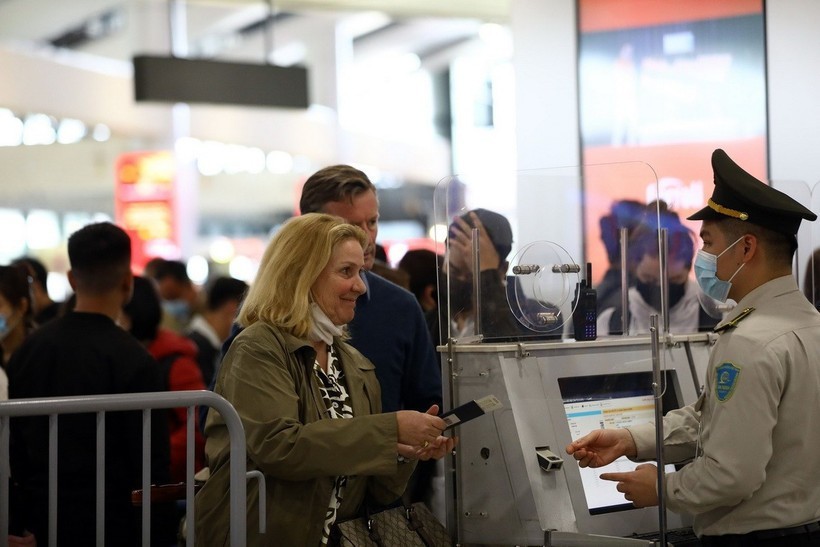 An aviation security official checks passenger information before security screening. (Photo: VNA) thi-thuc-2.jpg