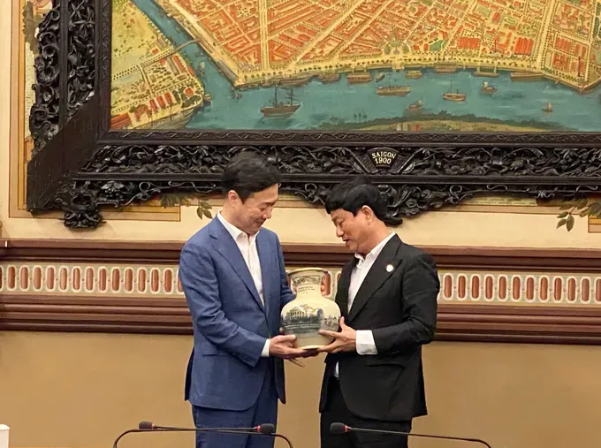 Mr. Vo Van Minh, Deputy Secretary of the Party Committee and Chairman of the Ho Chi Minh City People’s Council presents a commemorative gift to the Deputy Mayor of Daejeon. (Photo: SGGP/ Xuan Hanh) z6947324441665-8a5f383d820e59b7124cb0dffc787613-607-893.jpg