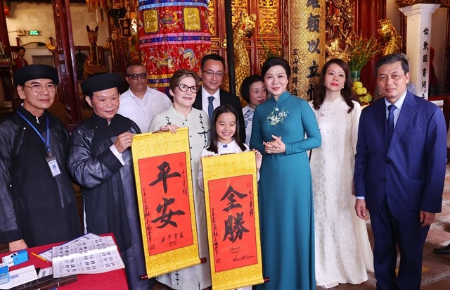 Cuban first lady Lis Cuesta Peraza is gifted calligraphy work from a local scholar at Ngoc Son Temple. 447310_5259731779194461_vncbtp.jpg