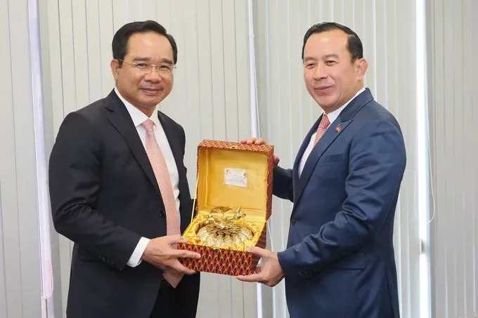 Leaders of Ho Chi Minh City and Cambodia present commemorative gifts to each other. (Photo: SGGP/ Hoang Hung) z6975134129581-3b933ccae635b61f0efa006bfe8a9801-2907-826.jpg