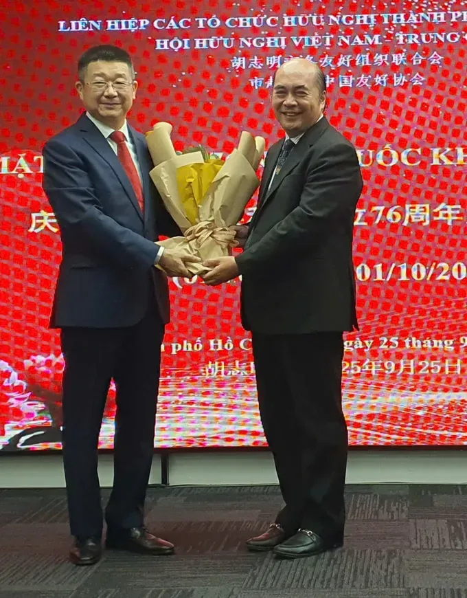 Chinese Consul General Tang Li receives a congratulatory bouquet from HUFO Vice Chairman Ho Xuan Lam. (Photo: SGGP/ Thuy Vu) img-20250925-190651-8140-1453.jpg