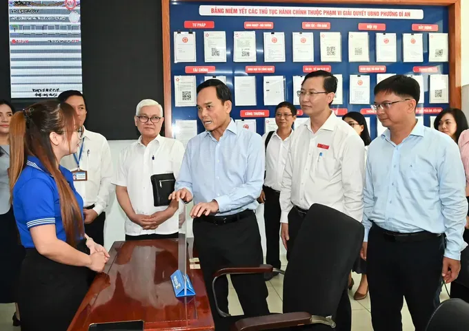 Ho Chi Minh City Party Secretary Tran Luu Quang greets staff at Di An Ward Public Administrative Service Center who assist citizens with administrative procedures. (Photo: SGGP/ Viet Dung) 2400287109729496478-5352-2977.jpg
