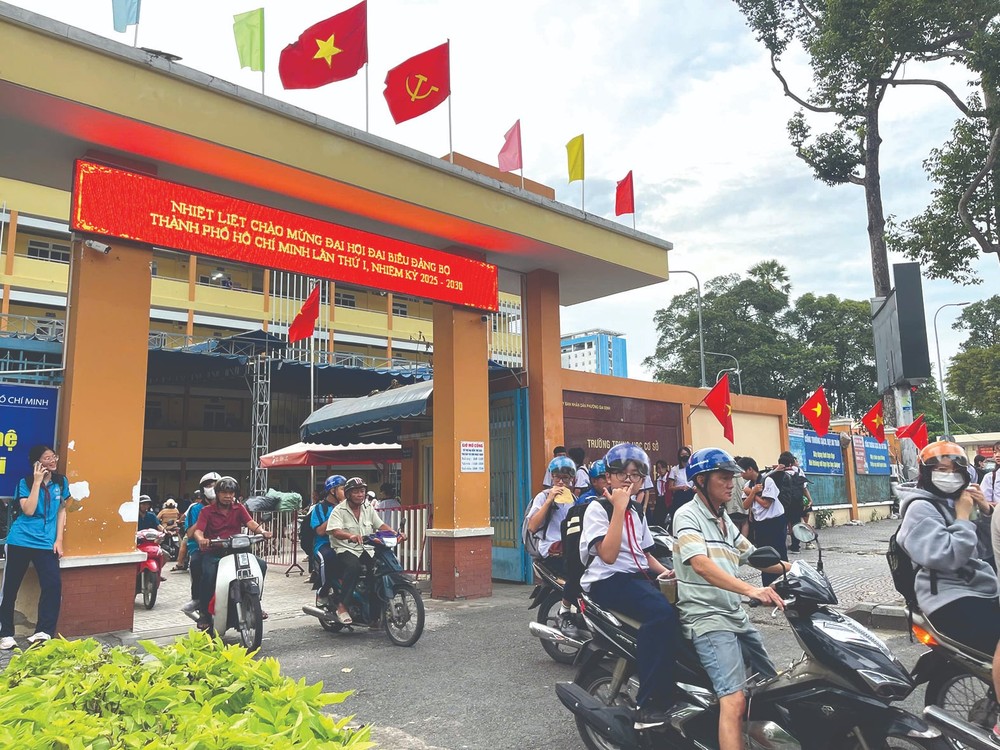 In front of Truong Cong Dinh Secondary School, Gia Dinh Ward, national and Party flags wave beside an LED screen displaying greetings for the congress. 867a31d5-f13f-46b7-9a57-9947247735be.jpg