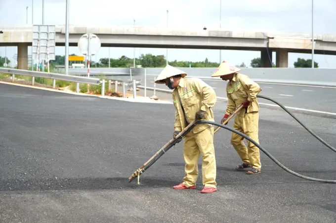 cong-nhan-lam-sach-mat-duong-de-chuan-bi-tham-nhua-lop-cuoi-cung-truoc-khi-thai-thac-cao-toc-2707-5549.jpg