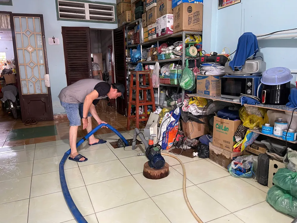 Người dân dùng máy bơm nước ra khỏi sàn nhà triều cường 19.jpg