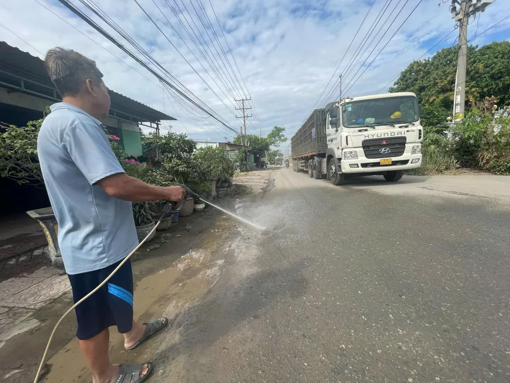 Щоб зменшити кількість пилу, люди поливають дорогу перед своїми будинками. đường 1.jpg