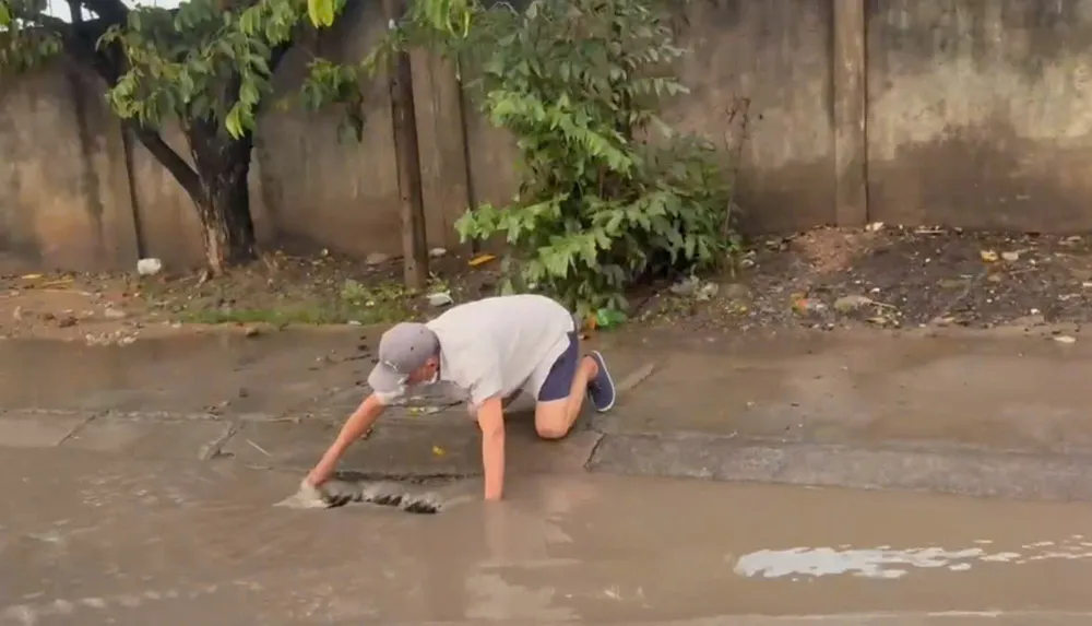 Dans le quartier de Thuan Giao, un habitant utilise ses mains pour ramasser les déchets dans les égouts afin de dégager le flux. 1..jpg