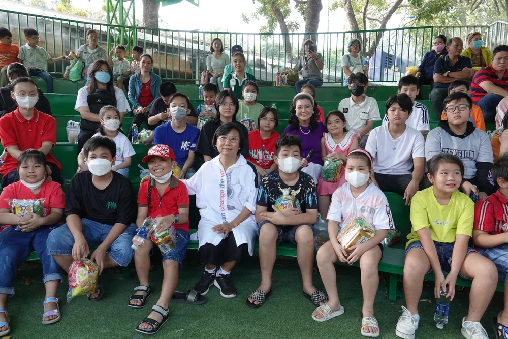 NSND Kim Cương chụp ảnh lưu niệm cùng các em thiếu nhi có người thân mất vì dịch bệnh Covid-19. Ảnh: THÚY BÌNH