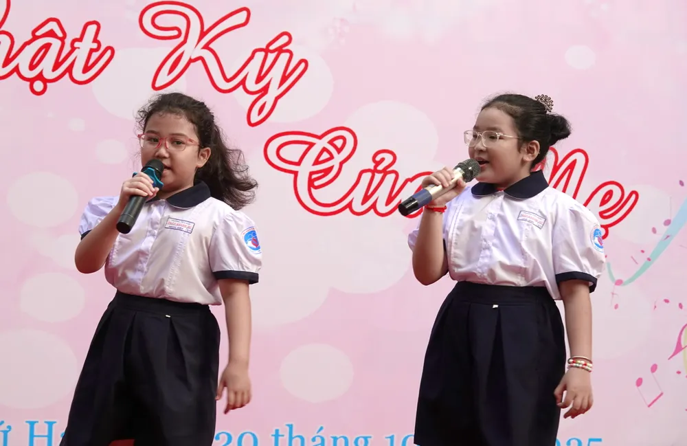 Hai em học sinh Ngọc Diệp và Lam Anh biểu diễn bài hát thiếu nhi "Mẹ ơi có biết". Ảnh: THÚY BÌNH song ca Mon qua tang co.JPG