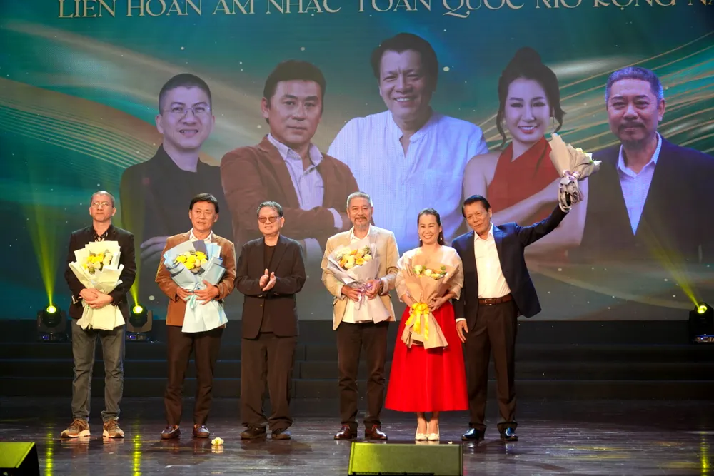 Thiếu tướng, nhạc sĩ Nguyễn Đức Trịnh, Chủ tịch Hội Nhạc sĩ Việt Nam, Trưởng Ban tổ chức liên hoan tặng hoa cho 5 thành viên Ban Giám khảo liên hoan năm nay. Ảnh: THÚY BÌNH DSC03166.JPG