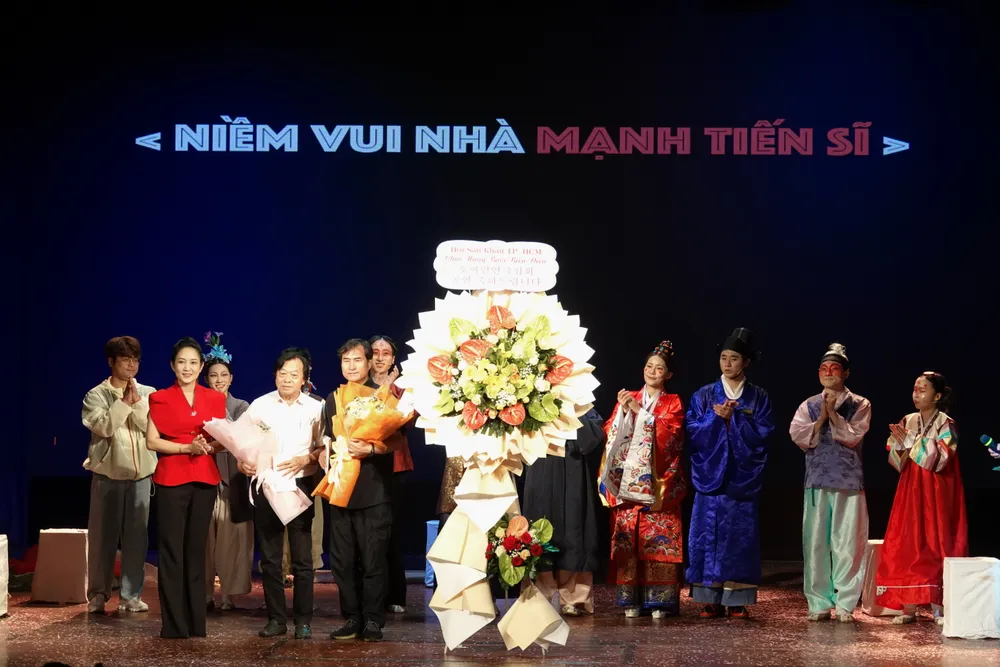 Phó Giám đốc Sở VHTT TPHCM tặng hoa chúc mừng hai đơn vị là Hội Sân khấu TPHCM và Đoàn nghệ sĩ Sân khấu TP Busan, Hàn Quốc đã phối hợp tổ chức biểu diễn thành công vở kịch "Niềm vui nhà Mạnh tiến sĩ". Ảnh: THÚY BÌNH