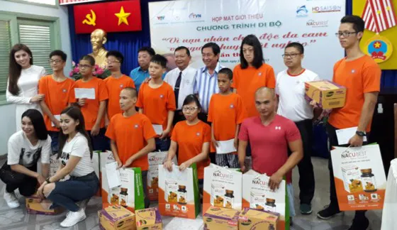 Đại diện nhà tài trợ và đại sứ chương trình đi bộ tặng quà cho nạn nhân chất độc da cam