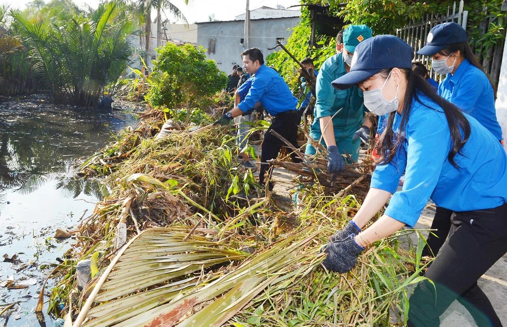 Thanh niên TPHCM tham gia dọn vệ sinh trên rạch Cây Me, quận 7 trong Ngày Chủ nhật xanh. Ảnh: VIỆT DŨNG