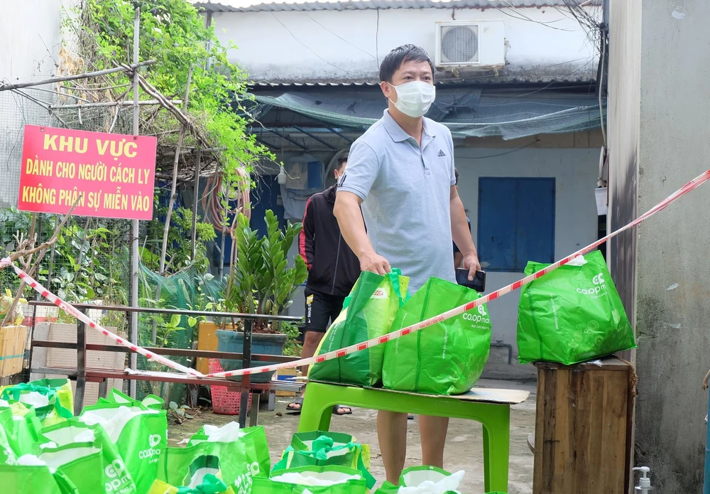 Người dân TP Thủ Đức ở khu phong tỏa, cách ly y tế nhận nhu yếu phẩm do địa phương hỗ trợ. Ảnh: THU HƯỜNG