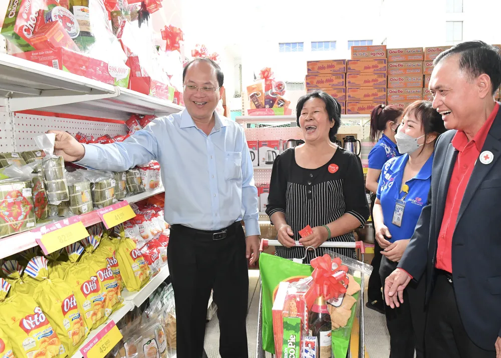 Phó Bí thư Thành ủy TPHCM cùng người dân tham quan các gian hàng tại phiên chợ 0 đồng. Ảnh: VIỆT DŨNG