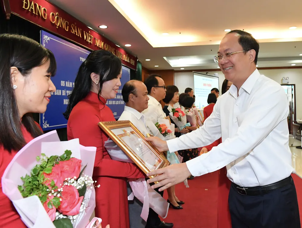 Đồng chí Nguyễn Hồ Hải tặng Bằng khen của Ban Thường vụ Thành ủy TPHCM cho các tập thể có thành tích xuất sắc trong thực hiện Chỉ thị 20. Ảnh: VIỆT DŨNG