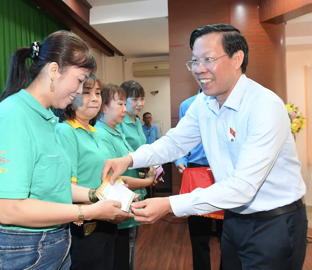 Chủ tịch UBND TPHCM Phan Văn Mãi tặng quà cho công nhân. Ảnh: VIỆT DŨNG