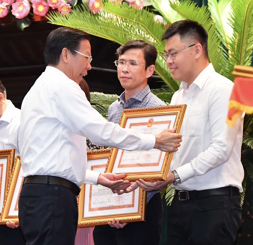 Chủ tịch UBND TPHCM Phan Văn Mãi tặng Bằng khen của UBND TPHCM đến các đơn vị đã làm tốt công tác tham mưu, biên soạn và hoàn thành Đề án trình Quốc hội ban hành Nghị quyết 98. Ảnh: VIỆT DŨNG