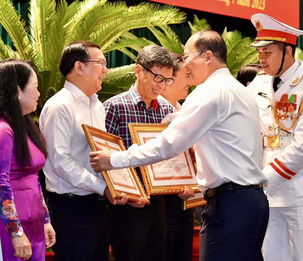 Phó Bí thư Thành ủy TPHCM Nguyễn Hồ Hải tặng Bằng khen của UBND TPHCM đến các đơn vị, cá nhân làm tốt công tác tham mưu, biên soạn và hoàn thành Đề án trình Quốc hội ban hành Nghị quyết 98. Ảnh: VIỆT DŨNG