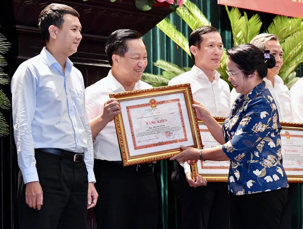 Chủ tịch Ủy ban MTTQ Việt Nam TPHCM Trần Kim Yến tặng Bằng khen của UBND TPHCM đến các cá nhân đã làm tốt công tác tham mưu, biên soạn và hoàn thành Đề án trình Quốc hội ban hành Nghị quyết 98. Ảnh: VIỆT DŨNG