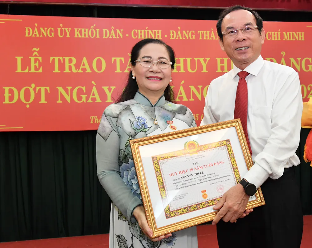 Bí thư Thành ủy TPHCM trao Huy hiệu 30 năm tuổi Đảng đến đồng chí Nguyễn Thị Lệ. Ảnh: VIỆT DŨNG