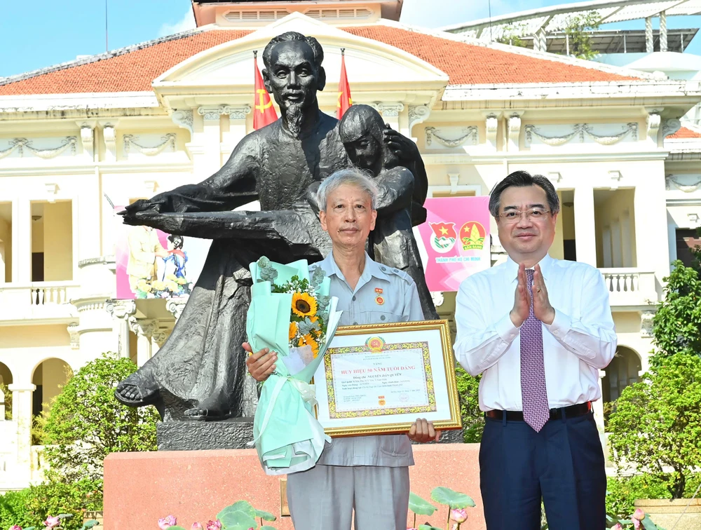 Đồng chí Nguyễn Thanh Nghị trao Huy hiệu 50 năm tuổi Đảng đến đồng chí Nguyễn Dân Quyền, đảng viên Chi bộ Tạp chí Cựu chiến binh Thành phố. Ảnh VIỆT DŨNG 15-5. 4.jpg