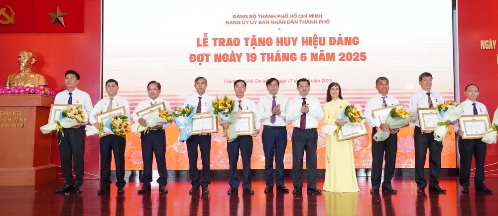 Đồng chí Dương Ngọc Hải và đồng chí Tăng Hữu Phong chúc mừng các đảng viên nhận Huy hiệu 40 năm tuổi Đảng. Ảnh: PHƯƠNG UYÊN 10.JPG