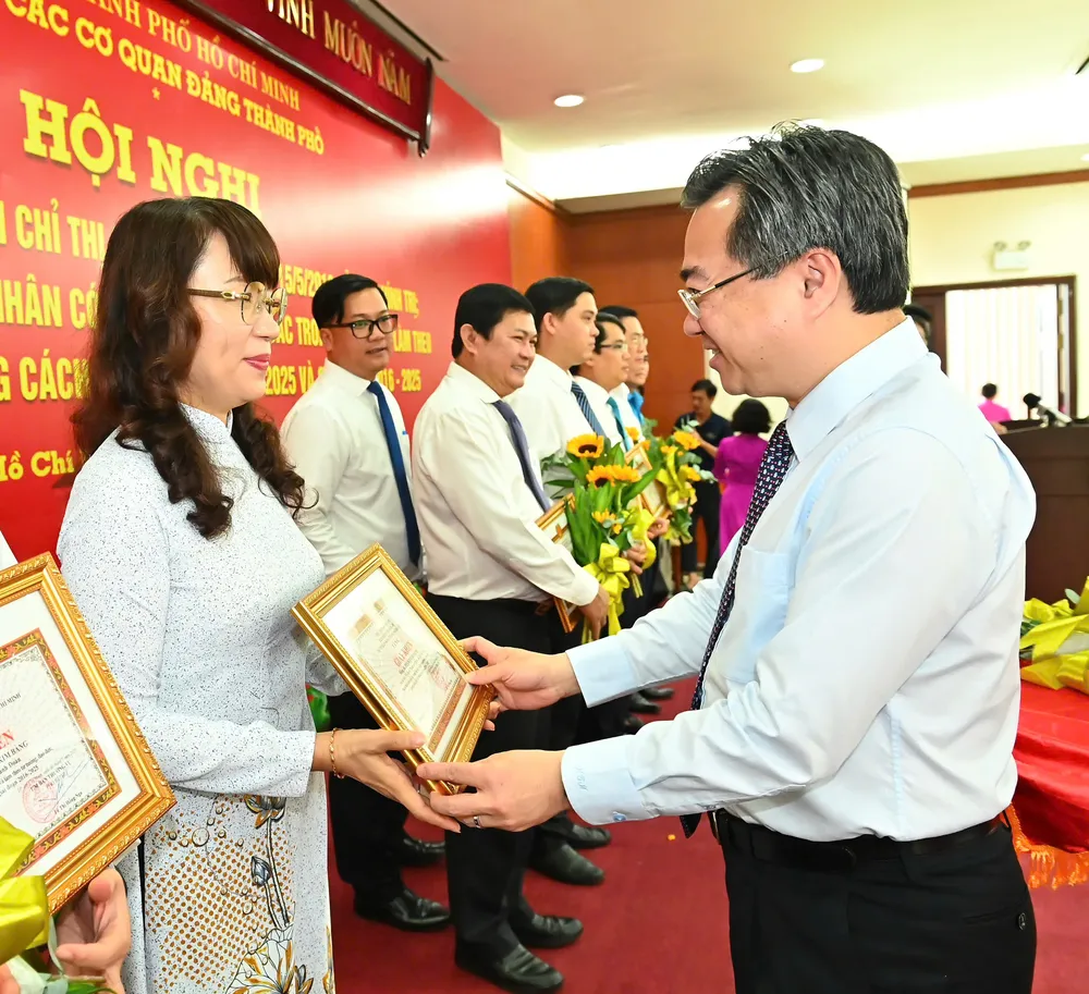 Phó Bí thư Thường trực Thành ủy TPHCM Nguyễn Thanh Nghị chúc mừng các cá nhân điển hình học và làm theo Bác giai đoạn 2016-2025. Ảnh: VIỆT DŨNG 11-6. 1.jpg