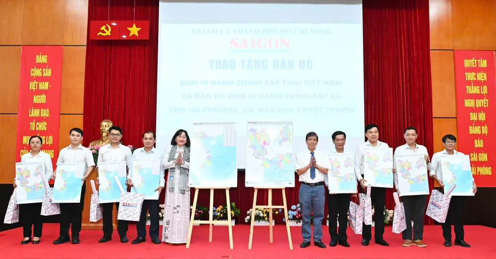Phó Tổng Biên tập Phụ trách Báo SGGP Nguyễn Khắc Văn và Phó Tổng Biên tập Báo SGGP Bùi Thị Hồng Sương tặng bản đồ đến đại diện các phường, xã. Ảnh: VIỆT DŨNG 7-7. 9.jpg