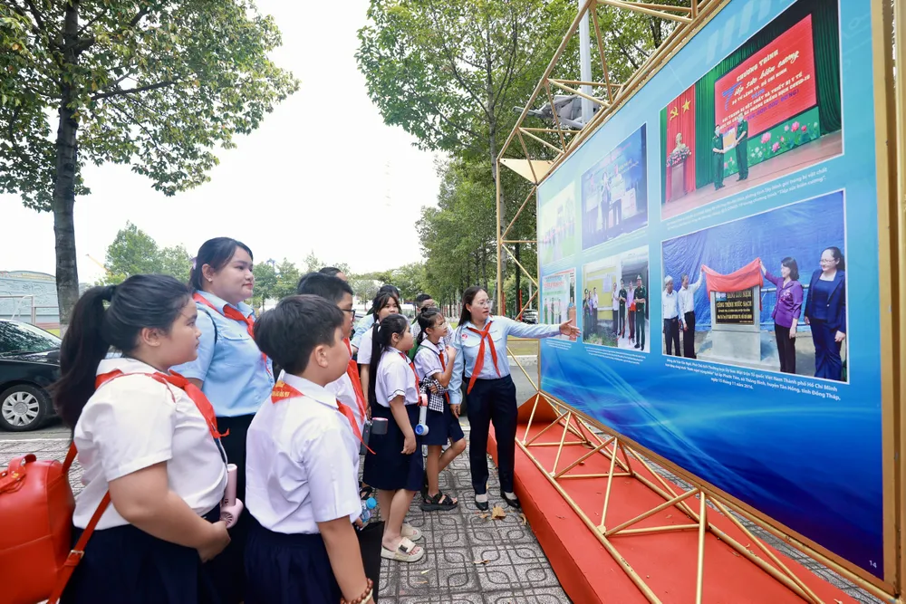 Các em học sinh tham quan triển lãm ảnh trong khuôn khổ hội nghị. Ảnh: DŨNG PHƯƠNG 11-7. 2.jpg