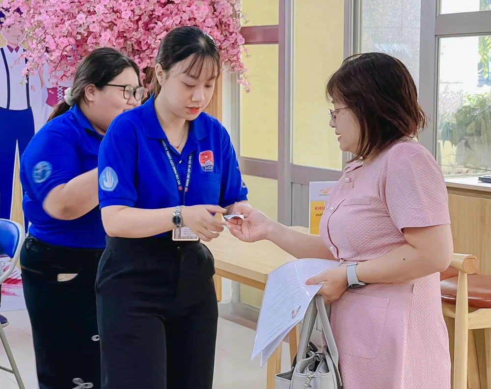 Sinh viên tình nguyện hỗ trợ người dân tới giải quyết thủ tục hành chính. Ảnh: PHƯƠNG UYÊN c9635451667cd022896d44.jpg
