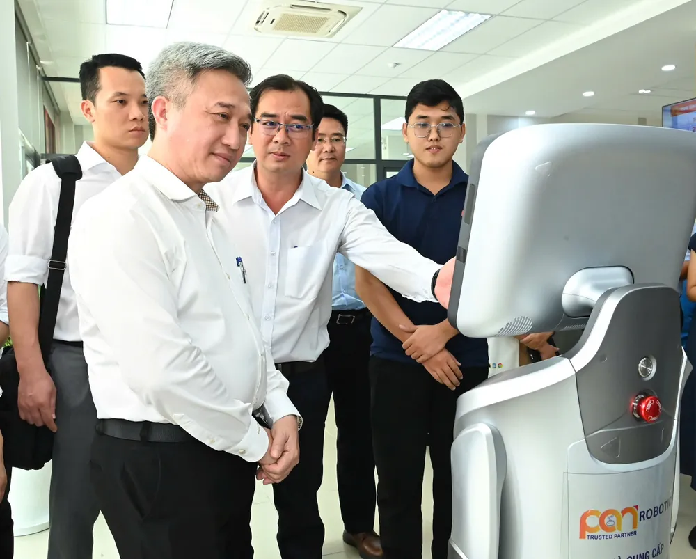 Đồng chí Đặng Minh Thông trải nghiệm robot phục vụ tại Trung tâm Phục vụ hành chính công phường Thủ Đức. Ảnh: VIỆT DŨNG 18-7. 11.jpg