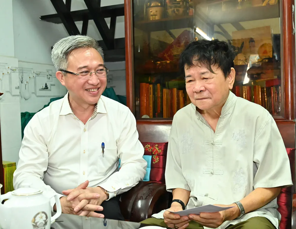 Phó Bí thư Thành ủy Đặng Minh Thông trân trọng cảm ơn những đóng góp của vợ chồng ông Nguyễn Thành Kham đối với sự nghiệp giải phóng dân tộc của Tổ quốc. Ảnh: VIỆT DŨNG 18-7. 16.jpg