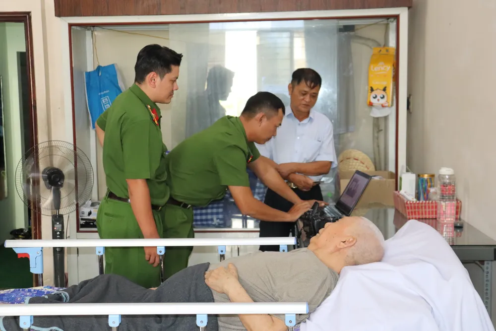 Công an phường Tân Sơn Nhất thực hiện thủ tục đổi thẻ Đảng tại nhà đảng viên. Ảnh: CẨM TUYẾT IMG_2941.JPG
