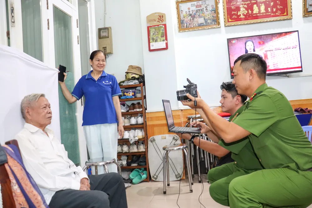 Công an phường Tân Sơn Nhất thực hiện thủ tục đổi thẻ Đảng tại nhà đảng viên. Ảnh: CẨM TUYẾT IMG_2971.JPG