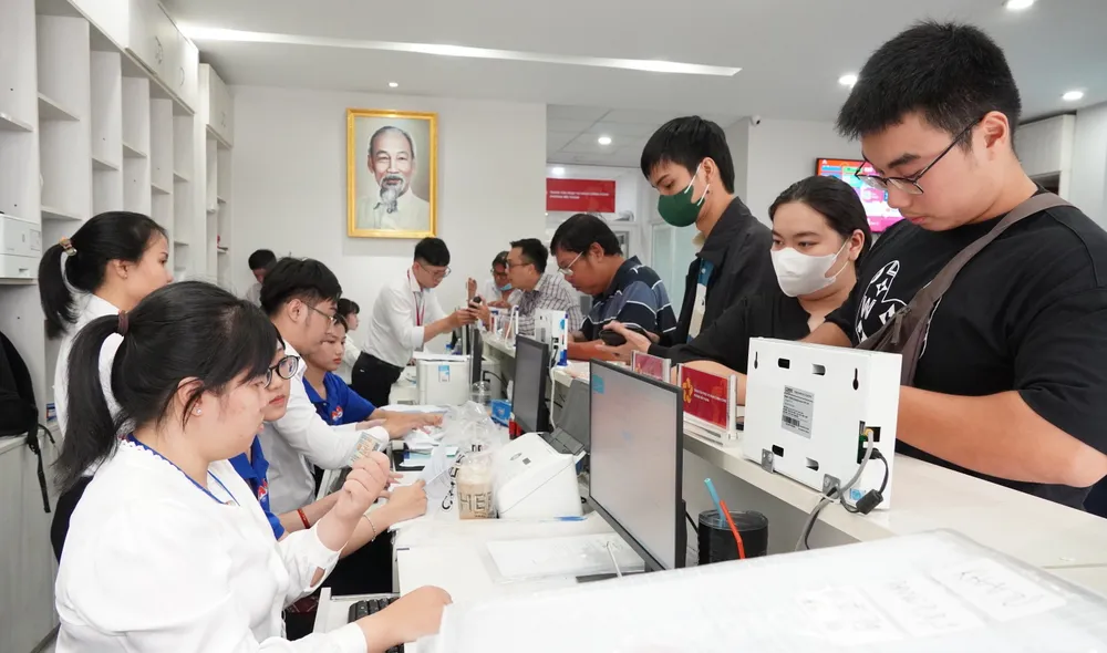 Công chức phường Bến Thành tiếp nhận thủ tục hành chính của người dân. Ảnh: PHƯƠNG UYÊN Công chức phường Bến Thành tiếp và giải quyết thủ tục hành chính cho người dân 2.JPG