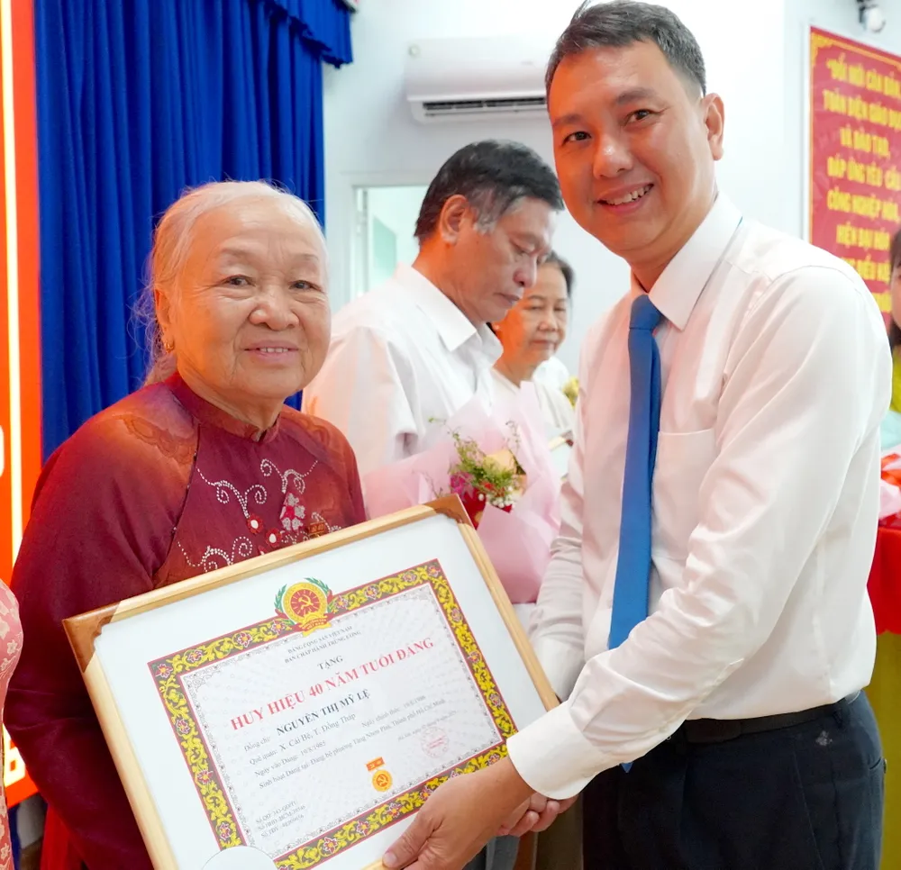 Bí thư Đảng ủy phường Tăng Nhơn Phú Nguyễn Bạch Hoàng Phụng trao Huy hiệu 40 năm tuổi Đảng đến các đảng viên 6HH06195.JPG