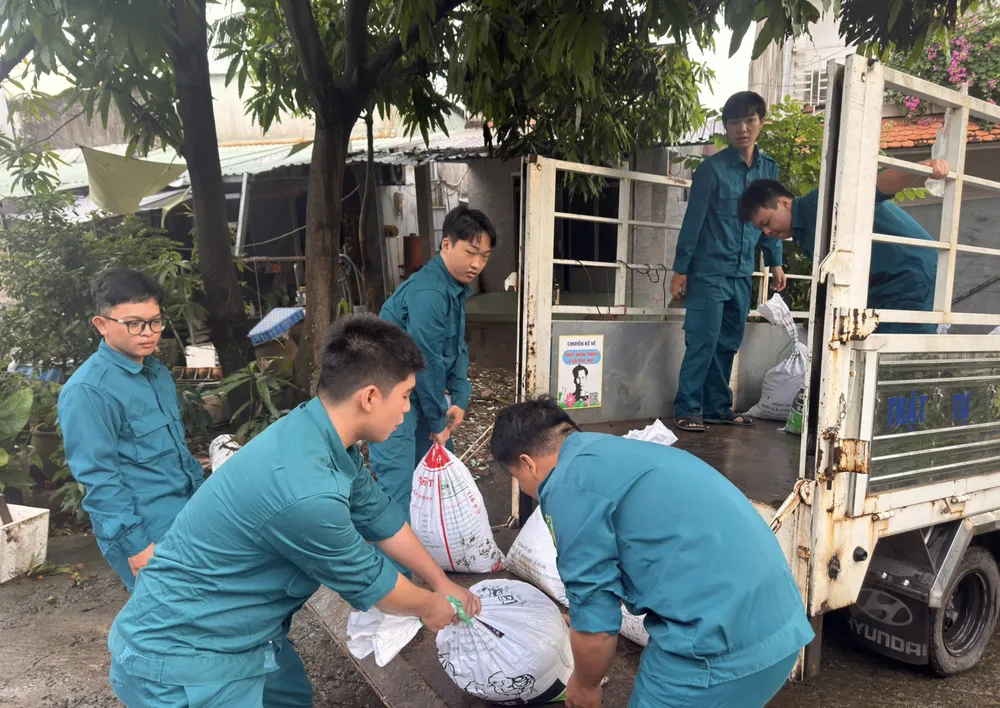 ກອງບັນຊາການທະຫານເຂດບິ່ງກວຍ ໄດ້ຂົນສົ່ງກະສອບຊາຍຢ່າງຮີບດ່ວນ ເພື່ອປ້ອງກັນບໍ່ໃຫ້ນ້ຳຖ້ວມສູງເຂົ້າໄປຫາຈຸດສຳຄັນ. ຮູບພາບ: MANH THANG Ảnh chụp Màn hình 2025-11-06 lúc 17.09.25.png