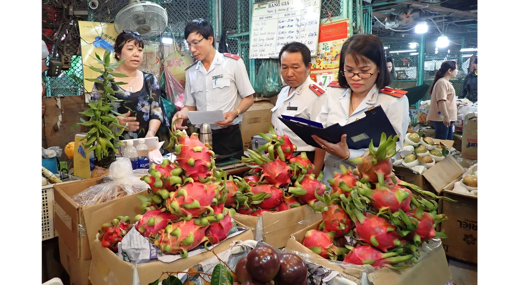 Đoàn kiểm tra nguồn gốc xuất xứ trái cây nhập vào chợ. Ảnh: HOÀNG HÙNG