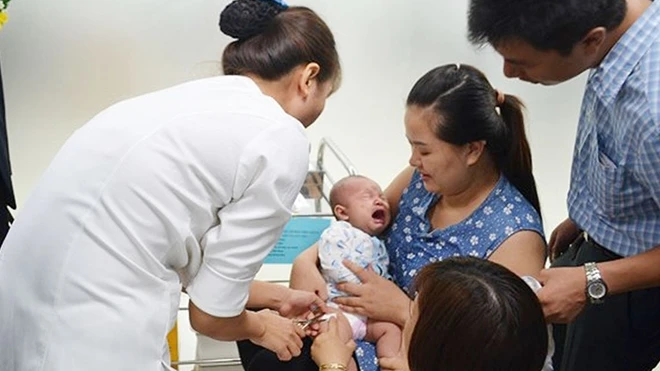 Nhân viên y tế tiêm vaccine cho trẻ em