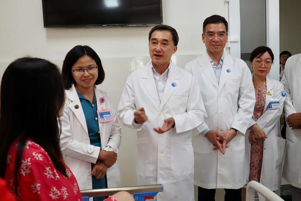 Thứ trưởng Bộ Y tế thăm, động viên và chúc mừng sản phụ đã can thiệp bào thai thành công vào sáng 9-6. Ảnh: HOÀNG HÙNG ee9a94cb972f23717a3e.jpg