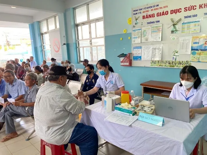 Nhân viên y tế đang lấy máu kiểm tra sức khỏe cho người cao tuổi xã An Nhơn Tây, TPHCM