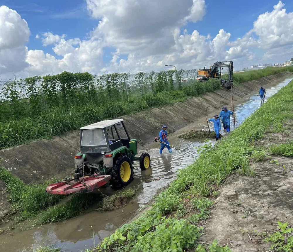 Nhân viên đang nạo vét kênh trong khu vực sân bay Tân Sơn Nhất
