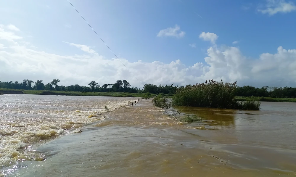 Mưa lớn, nước sông chảy siết, tràn qua tuyến đường vào sáng ngày 5-12. Ảnh: NGUYỄN TRANG Mưa lớn, nước sông chảy siết, tràn qua tuyến đường vào sáng ngày 5-12. Ảnh: NGUYỄN TRANG