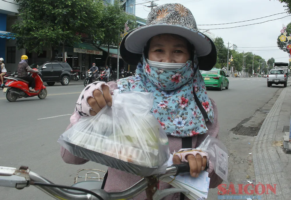 Một người bán vé số vui mừng khi nhận được phần cơm trưa. Ảnh: NGUYỄN TRANG Một người bán vé số vui mừng khi nhận được phần cơm trưa. Ảnh: NGUYỄN TRANG