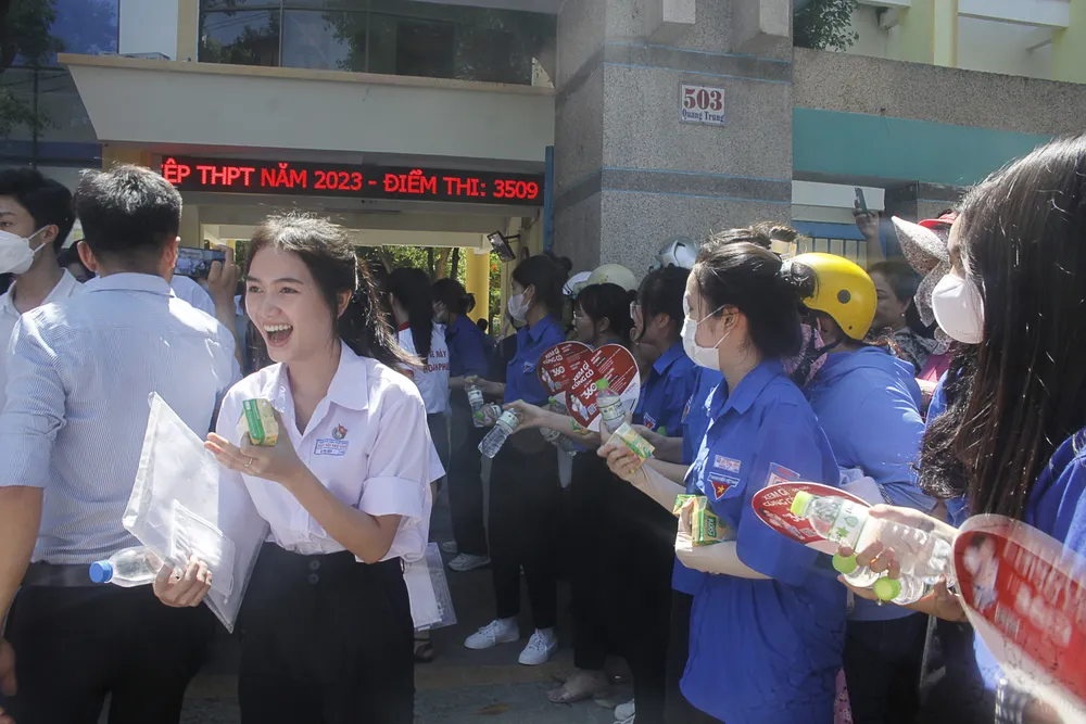 Các tình nguyện viên phát nước, sữa cho các thí sinh tại điểm thi Trường THPT Trần Quốc Tuấn. Ảnh: NGUYỄN TRANG