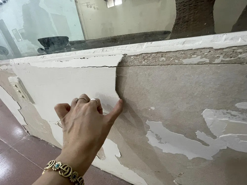 Tường nứt và rơi ra từng mảng. Ảnh: NGUYỄN TRANG