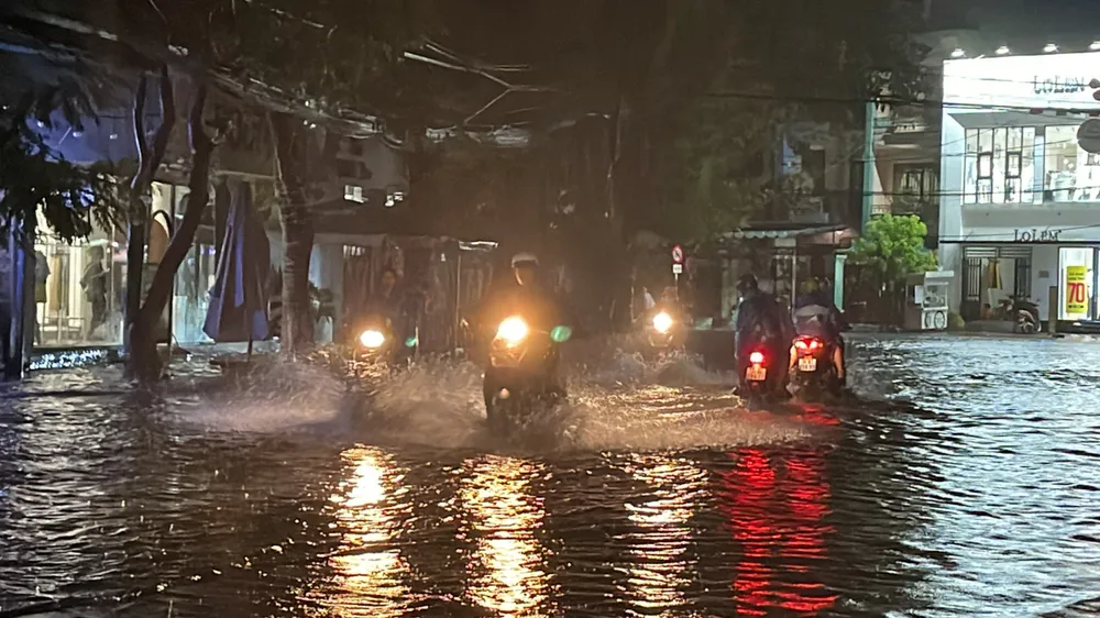 Người dân vất vả di chuyển trên đường bị ngập nước