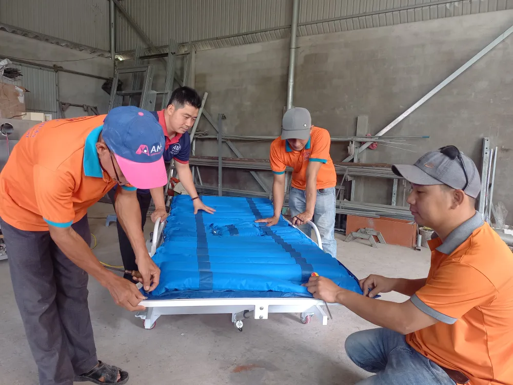 Anh Nở và nhóm thợ tối ưu giải pháp cho giường y tế đa năng. Ảnh: NGUYỄN TRANG