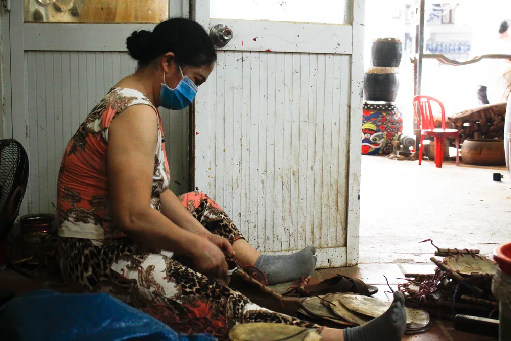 Phụ nữ giúp đỡ khâu làm mặt trống. Ảnh: NGUYỄN TRANG Phụ nữ giúp đỡ khâu làm mặt trống. Ảnh: NGUYỄN TRANG